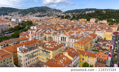 Aerial view of Nice, France, showcasing the vibrant Old Town with its colorful buildings and iconic terracotta rooftops. Surrounded by green hills Aerial view of Nice, France, showcasing the vibrant Old Town with its colorful buildings and iconic terracotta rooftops. Surrounded by green hills 119355584