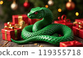 Green snake lies near the Ghristmas gifts. Symbol of the coming New Year 119355718
