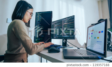 Asian prompt engineer develop coding app with software data sitting in front of computer monitor at office 119357188