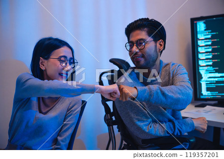 asian and Indian Developer team clapping hand for project success with software computer at night in office asian and Indian Developer team clapping hand for project success with software computer at night in office 119357201