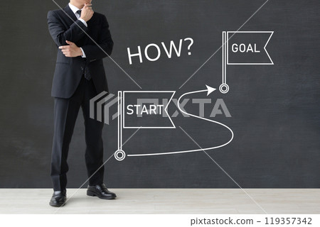 A businessman thinking about the path from start to finish A businessman thinking about the path from start to finish 119357342