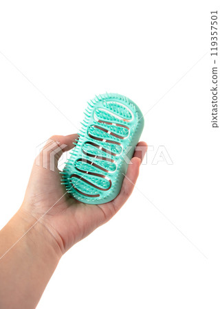 Female hand holding aroma hair comb for massage of head isolated on white background. 119357501