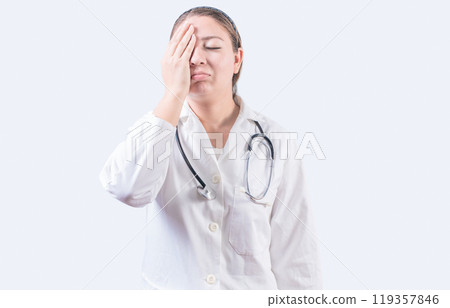 Stressed female doctor with hand on forehead isolated. Exhausted young female doctor with hand on forehead Stressed female doctor with hand on forehead isolated. Exhausted young female doctor with hand on forehead 119357846