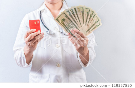 Female doctor hands holding credit card and money isolated. Unrecognizable doctor holding money and credit cards isolated 119357850