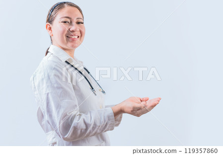 Beautiful smiling female doctor showing an advertisement with palms. Happy female doctor presenting something with palms Beautiful smiling female doctor showing an advertisement with palms. Happy female doctor presenting something with palms 119357860