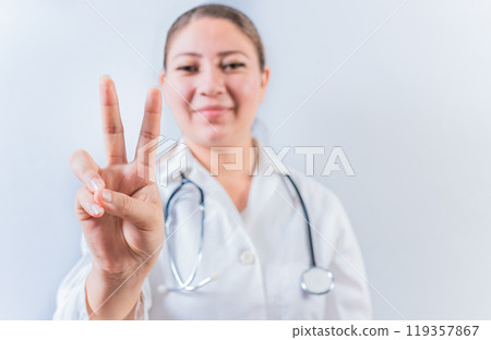Female doctor counting number TWO isolated. Young female doctor counting number 2 on isolated background 119357867