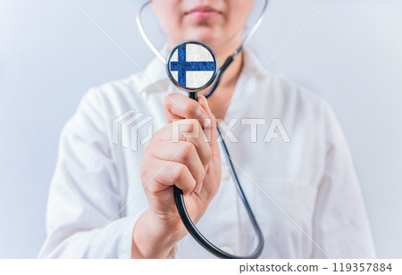 Female doctor holding stethoscope with Finland flag. Finland Health and Care Concept Female doctor holding stethoscope with Finland flag. Finland Health and Care Concept 119357884