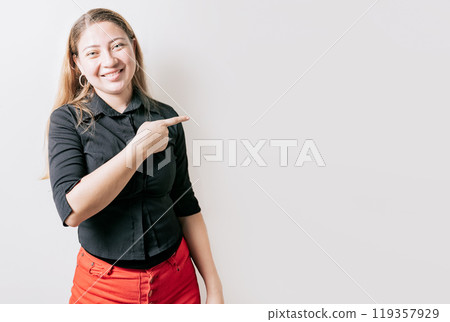 Smiling attractive young woman pointing an advertising isolated. Beautiful young girl pointing to a banner to the side. Happy latin woman pointing a promo Smiling attractive young woman pointing an advertising isolated. Beautiful young girl pointing to a banner to the side. Happy latin woman pointing a promo 119357929