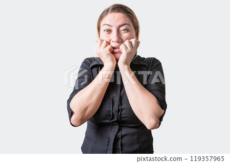 Worried girl biting her nails isolated. Anxious person biting her nails, looking at camera 119357965