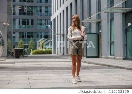 A Stylish Woman Happily Enjoying a Beautiful Sunny Day in an Urban Setting Full of Life 119358169