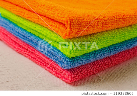 A stack of colored cloth , microfiber, for cleaning the house, on a white table, horizontal, no people, 119358605