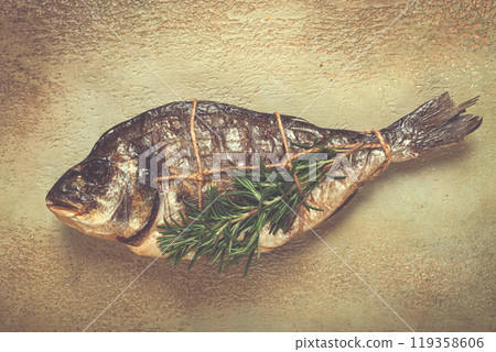 hot smoked dorado fish, with a sprig of rosemary, tied with a rope, on the table, top view, smoked fish, close-up, no people, 119358606