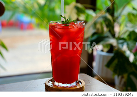 watermelon juice single-colored transparent cocktail, refreshing in a low glass with ice cubes and taste of berries, cherries, strawberries, greiprut. Side view. Isolated white background. Drink for 119359242