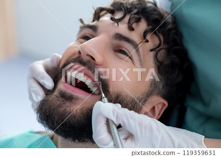 Unknown dentist doing oral examination with advanced dental equipment for patient 119359631