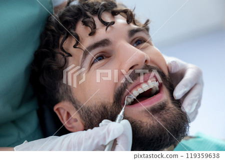 Unknown dentist doing oral examination with advanced dental equipment for patient 119359638
