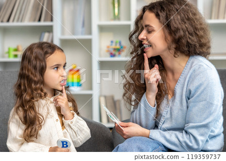 Cute long-haired girl having speech therapy session with the doctor 119359737
