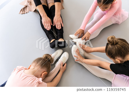 Ballerina children in studio doing stretching before ballet training Ballerina children in studio doing stretching before ballet training 119359745