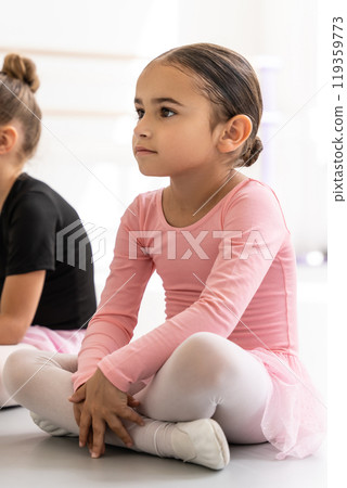 Little girl ballet dancer sitting on floor in dance class studio Little girl ballet dancer sitting on floor in dance class studio 119359773