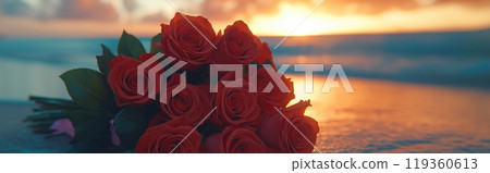 A bouquet of red roses lying on the sandy shore, with a vibrant sunset reflecting on the ocean 119360613