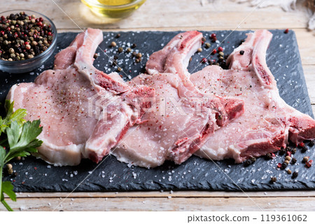 Fresh uncooked pork chops on wooden table Fresh uncooked pork chops on wooden table 119361062