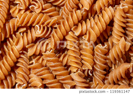 Uncooked Whole Grain Fusilli Pasta Background Uncooked Whole Grain Fusilli Pasta Background 119361147