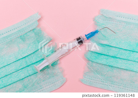 Broken Medical Syringe and Torn Medical Face Mask on the Pink Background 119361148