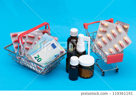 Pills and Capsules in Shopping Cart on Blue Background 119361191
