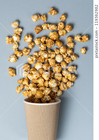Sweet caramelized popcorn spilled out of the glass. Sweet caramelized popcorn spilled out of the glass. 119362982