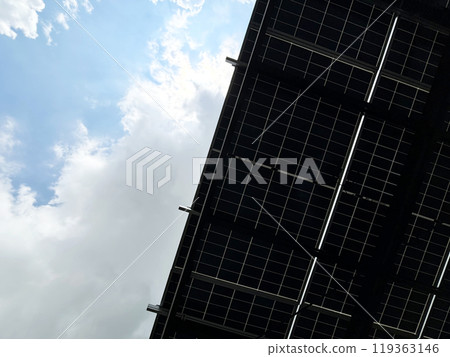 Solar cells roof for green energy, view against the blue sky under the solar cells roof of a parking lots, space for copy and design, landscape image. Solar cells roof for green energy, view against the blue sky under the solar cells roof of a parking lots, space for copy and design, landscape image. 119363146