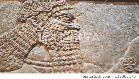 Close-up view on Winged Figure. Architectural Fragment Of Panel From Northwest Palace Of Ashurnasirpal Ii By Neo Assyrian Period. Depicted Is Winged Human Divine Spirit, Protective Spirit. High Priest 119363170