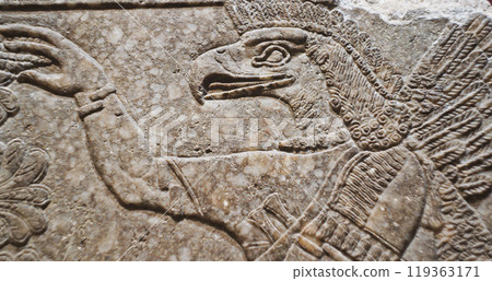 Close-up view on Eagle-headed Winged Figure And Sacred Trees. Architectural Fragment Of Panel From Northwest Palace Of Ashurnasirpal Ii By Neo Assyrian Period. Winged Bird Divine Spirit. Symbol Of Close-up view on Eagle-headed Winged Figure And Sacred Trees. Architectural Fragment Of Panel From Northwest Palace Of Ashurnasirpal Ii By Neo Assyrian Period. Winged Bird Divine Spirit. Symbol Of 119363171