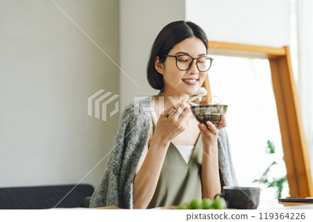 年輕女子在碗裡吃米飯 119364226
