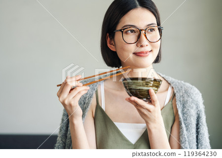 年輕女子在碗裡吃米飯 119364230