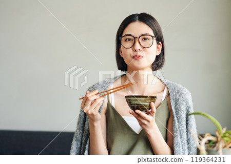 A young woman eating rice A young woman eating rice 119364231