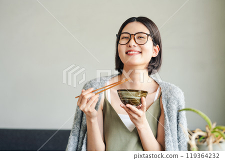 A young woman eating rice 119364232