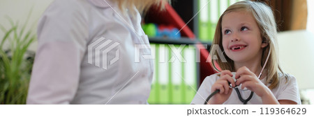 Curious little girl holds stethoscope ready to help doctor Curious little girl holds stethoscope ready to help doctor 119364629