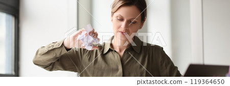 Disappointed woman crumples paper sheet with project plan Disappointed woman crumples paper sheet with project plan 119364650