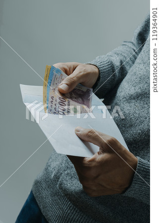 man taking out or puting some forints into an envelope 119364901