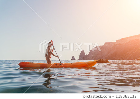 Kayaking Woman Sea - Woman kayaking on the ocean with a mountain in the background. Kayaking Woman Sea - Woman kayaking on the ocean with a mountain in the background. 119365132