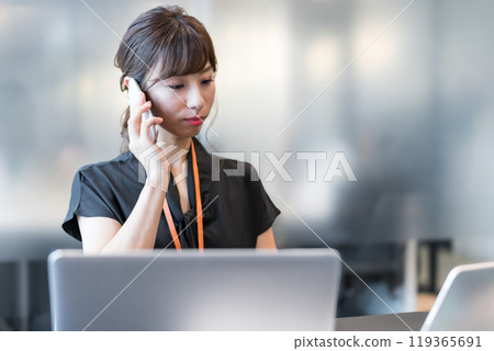 A business person multitasking with a smartphone in one hand A business person multitasking with a smartphone in one hand 119365691