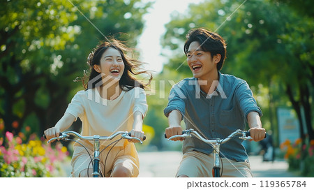 Smiling Asian couple enjoying cycling 119365784