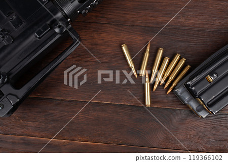Rifle and Ammunition with magazine on wooden table Rifle and Ammunition with magazine on wooden table 119366102