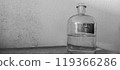 Glass Bottle with Sulfuric Acid Solution Against a Textured Wall 119366286