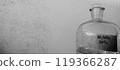 Glass Bottle with Sulfuric Acid Solution Against a Textured Wall 119366287
