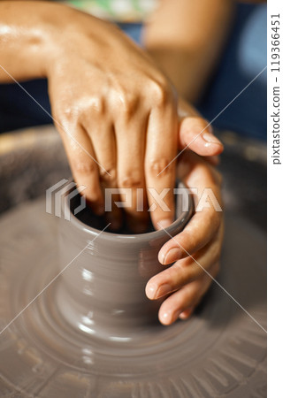 Hands of craftsman artist working on pottery wheel Hands of craftsman artist working on pottery wheel 119366451