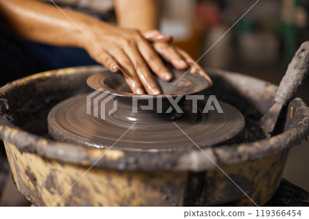 Hands of craftsman artist working on pottery wheel Hands of craftsman artist working on pottery wheel 119366454
