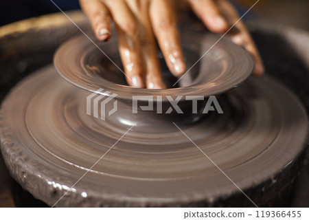 Hands of craftsman artist working on pottery wheel Hands of craftsman artist working on pottery wheel 119366455
