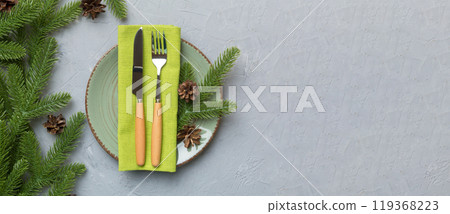 Christmas table place setting with christmas decor and plates, kine, fork and spoon. Christmas holiday background. Top view 119368223