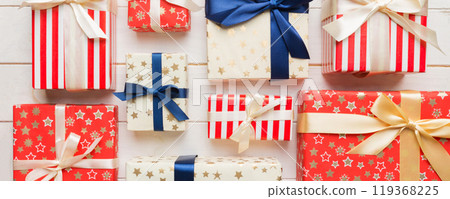 A lot of Christmas gift boxes in colored paper decorated on table, Top view close up. Many present New Year gift A lot of Christmas gift boxes in colored paper decorated on table, Top view close up. Many present New Year gift 119368225
