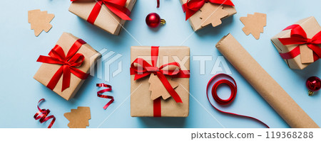 Christmas kraft gifts box with ribbon on colored background. Cozy Christmas still life, birthday or new year 119368288